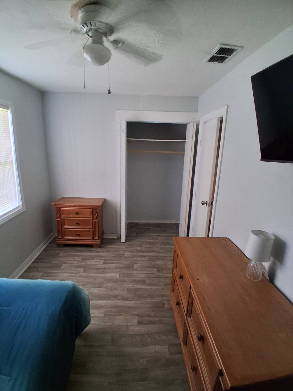 Archived furnished room view with closet, dresser, ceiling fan, and TV