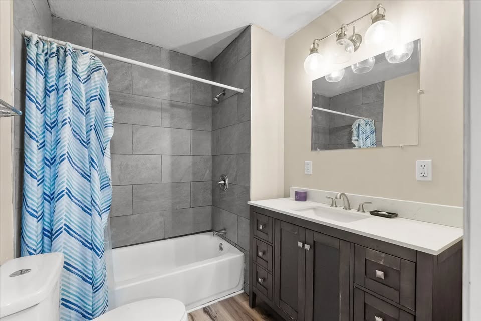 Shared bathroom with vanity and tub-shower